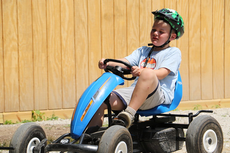 Boy riding a go-cart at summer camp