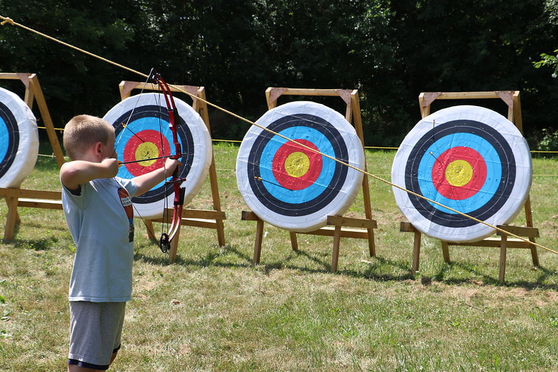 Boy doing archery at day camp