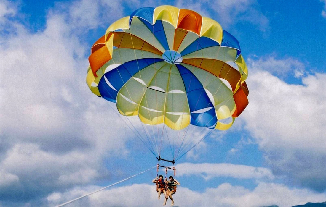 Two campers from Los Angeles enjoying the parasailing activity at Aloha Beach Camp's Hawaii overnight summer camp on the north shore of Oahu, Hawaii.