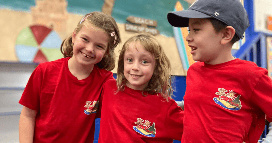 Three campers at Camp Kids Club wearing red camp t-shirts