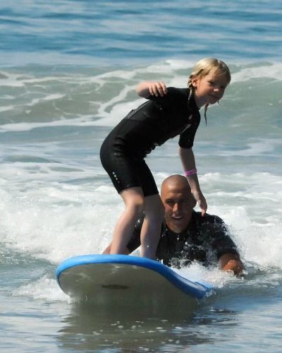 Surf instructor Trevor Kilroy teaches a young camper how to surf at Aloha Beach Camp in Malibu