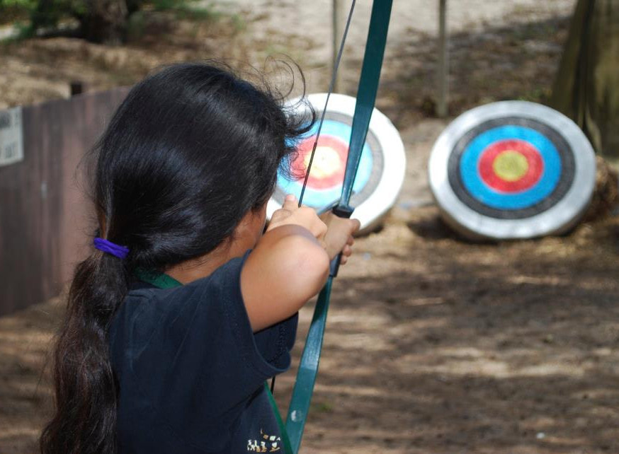 Girl doing archery at summer camp