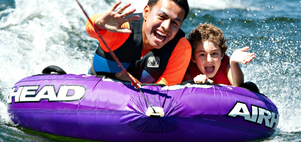 Boy and his counselor tubing together at Castaic Lake at Aloha Beach Camp.