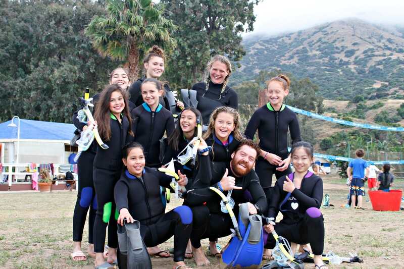 Happy campers and staff in wetsuits after enjoying a Scuba diving activity. 