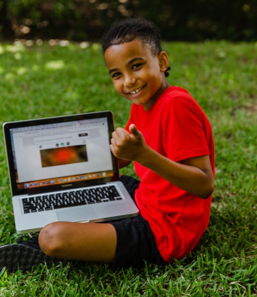 Boy attending virtual summer camp with his computer at Clubba