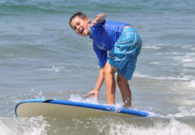 Boy from Malibu surfing at Fitness by the Sea Beach Camp