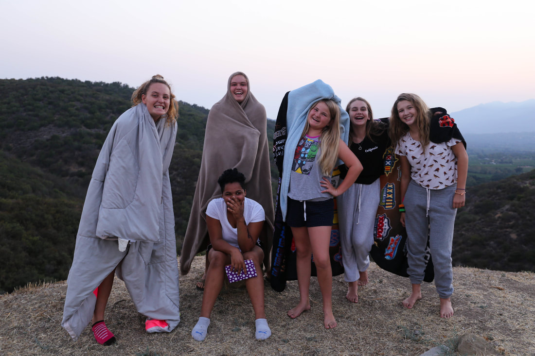 Six girls standing on the top of a large rock at Amplify Sleep Away Camp for Girls