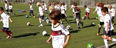 Group of kids playing soccer on a big grass field at Hollywood Soccer Academy Summer Camp