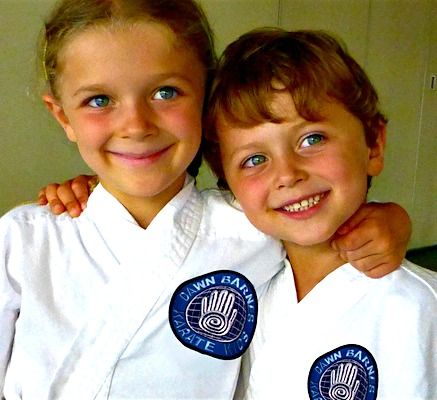 Happy boy and girl wearing Karate Kamp uniforms at Dawn Barnes' Karate Camp in Santa Monica.