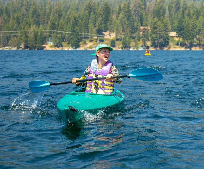 Camper kayaking on the lake at Kennolyn Camps. This is a traditional day camp everyone will enjoy!