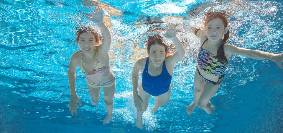 Kids swimming in the pool at summer camp in Pasadena