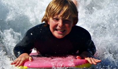 Boy boogie boarding at Aloha Beach Camp.