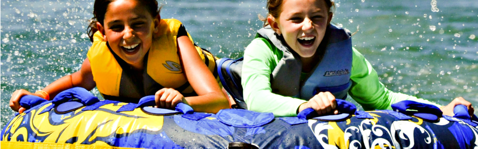 Two girls tubing at Castaic Lake at Aloha Beach Camp Summer Camp