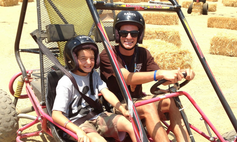 Camper and his camp counselor riding a go cart together at Phoenix Ranch Day Camp in Simi Valley.