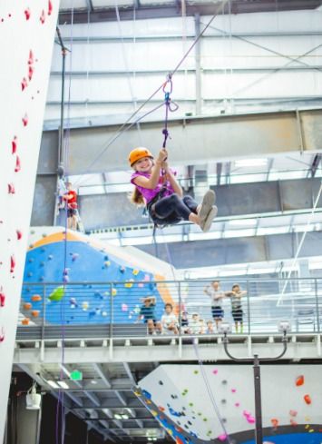 Girl swinging from a zip line at Sender One Rock Climbing Camp in Los Angeles
