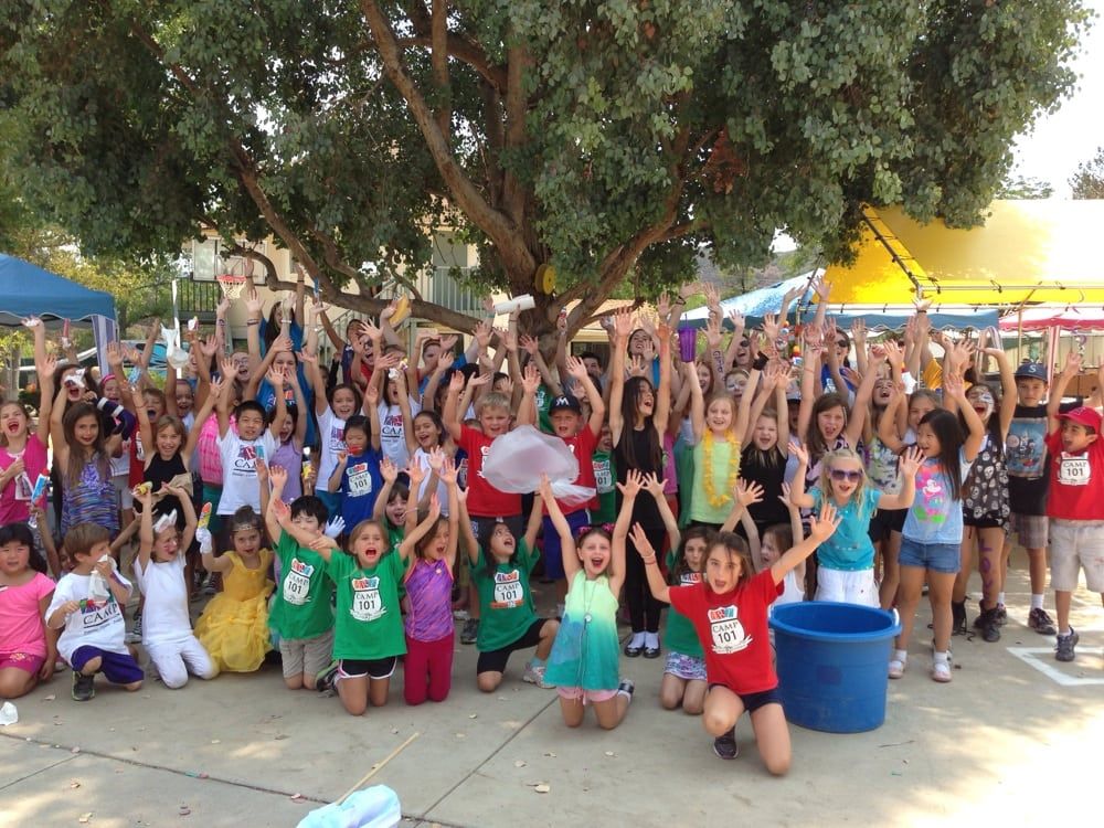 Group photo of all the campers and staff at Summer Art Academy in Agoura with their hands up in the aircture