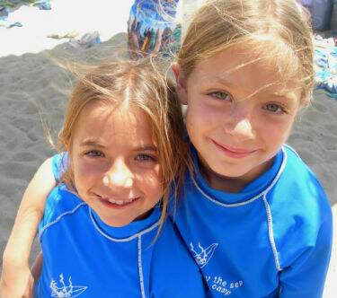 Two girls from Santa Monica with arms around each other at Fitness by the Sea Beach Camp.